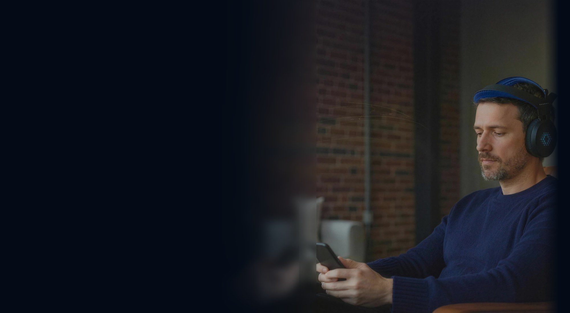 A man wearing the Sens.ai headset, following a session on his phone